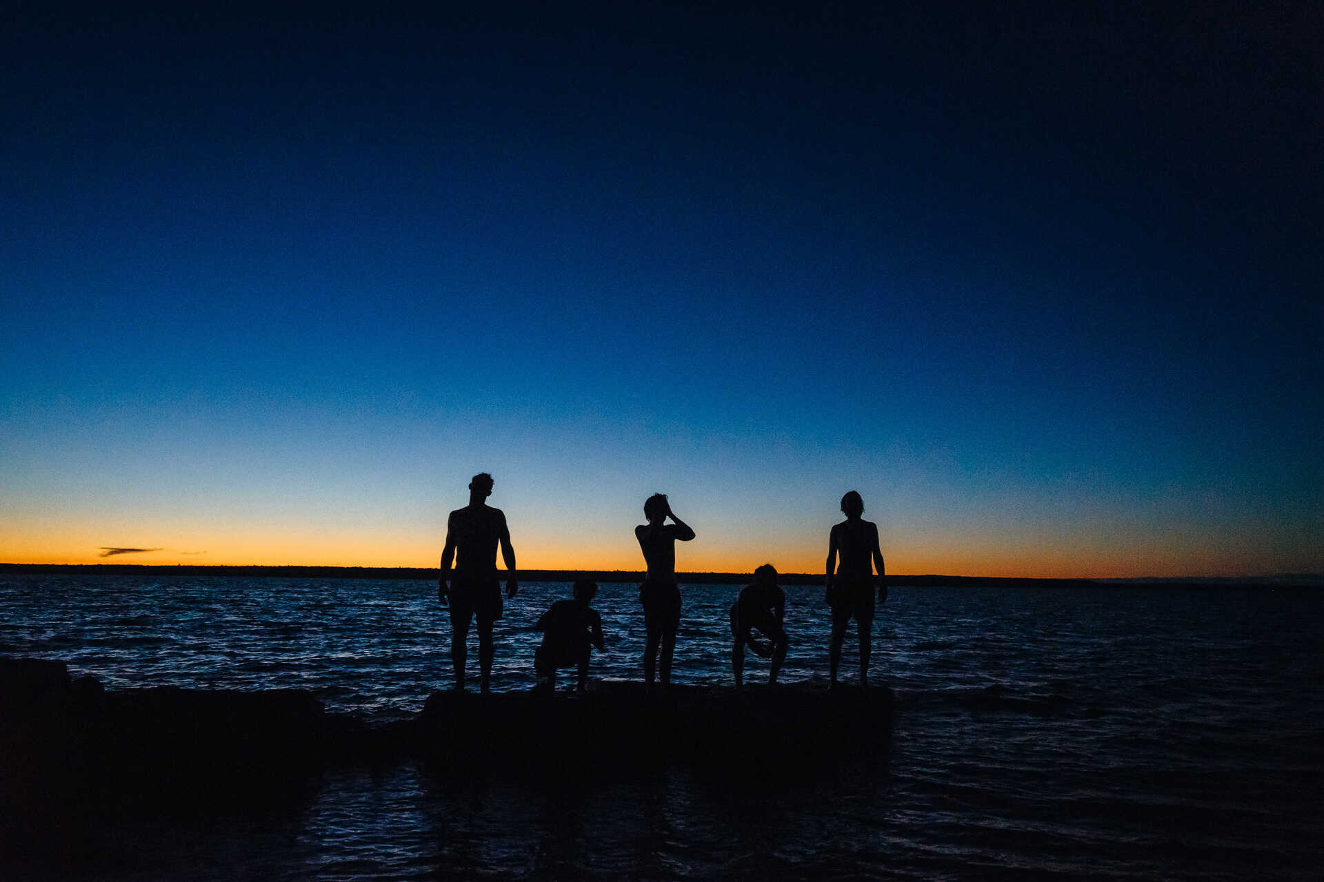 Five men in silhouette at Rabbit Island in Torch Lake Township, Michigan